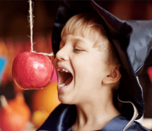 A young boy partakes in the halloween tradition of snap apple