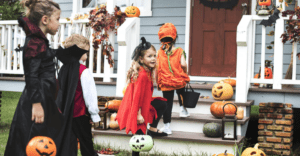 children line up to collect treats in costumes as a halloween tradition