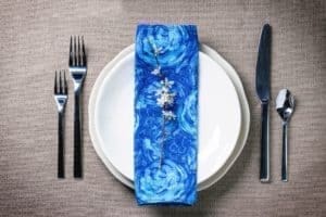 A blue table setting with silverware - Hospitality