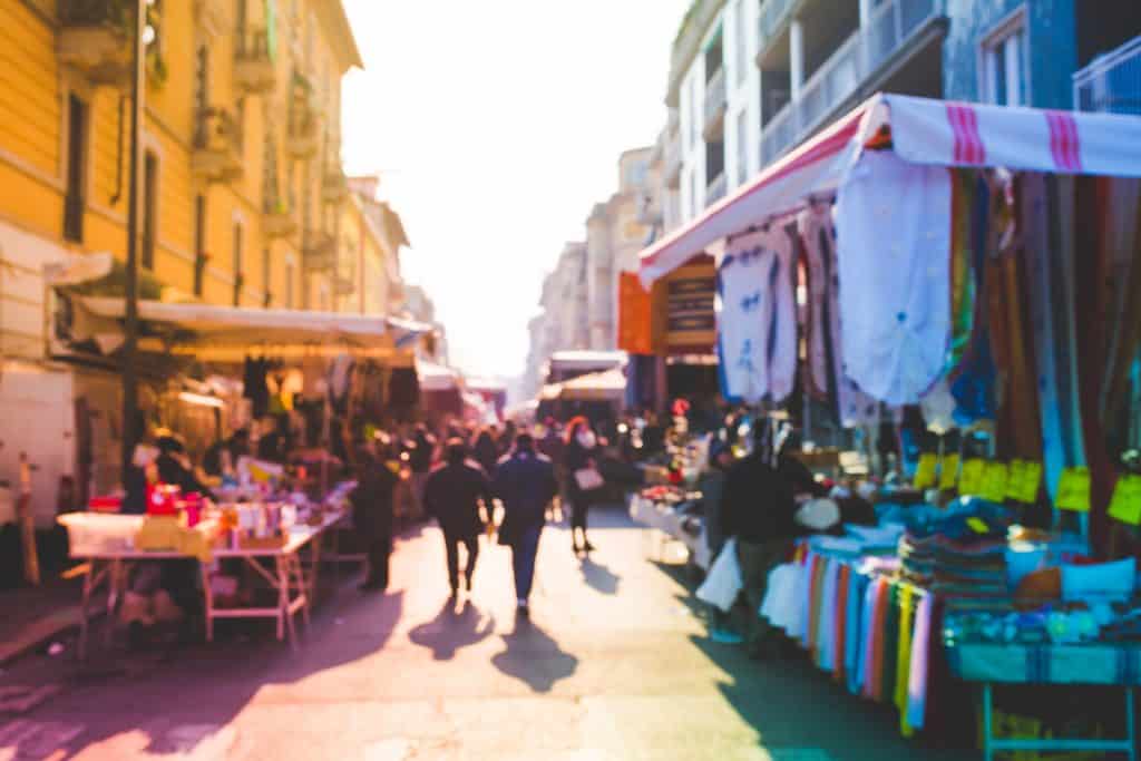 A blurred image of people at a street fair