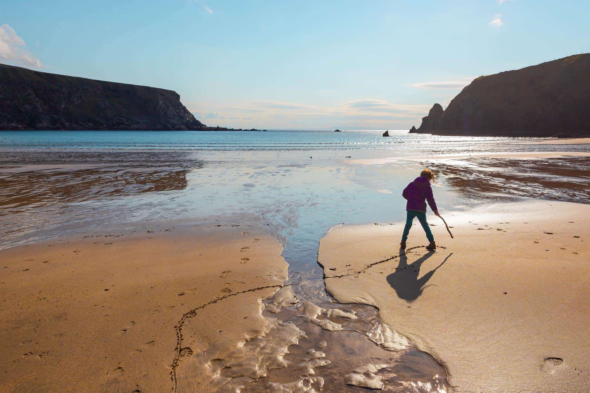 A child playing on the beach of Malin Beg, County Donegal, Ireland