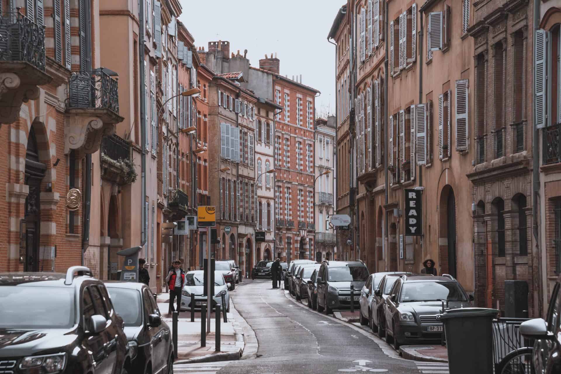 A street view photo of the famous pink and red buildings of Toulouse