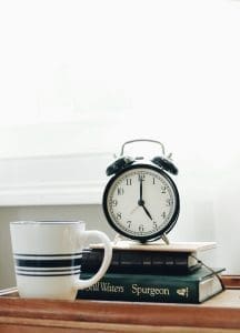 An alarm clock with coffee and books