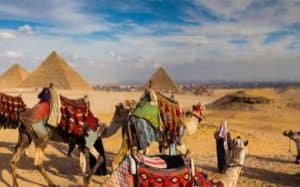 a picture of the pyramids and people riding camels some of the adventures to have in egypt