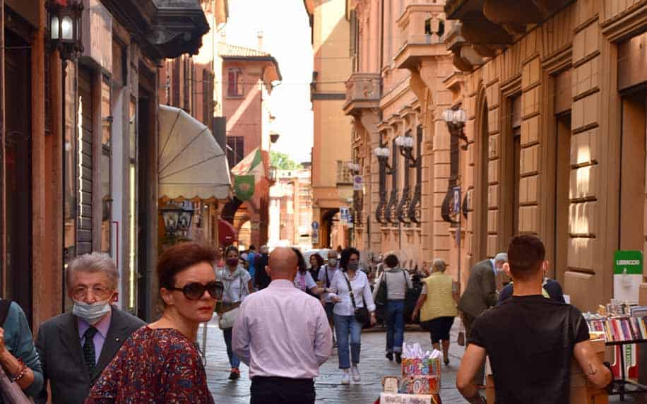 people walking through the medieval streets of bologna