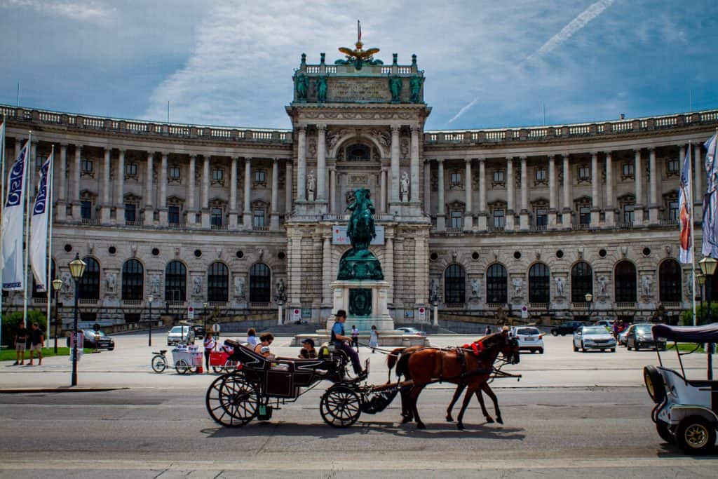 Cart pushing by a house in the presence of Hofburg Palace, Vienna, Austria 
