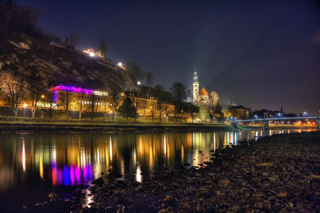 A beautiful shot of the historic city of Salzburg reflecting in the river during nighttime