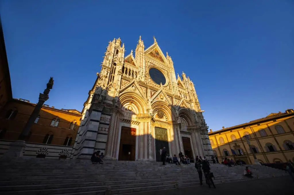 38758358 siena italyoctober 13 2018 sunset and view of sienas cathedral of santa maria assunta duomo di siena in siena 1 A beautiful city in the region of Tuscany, Siena is only 48 km south of Florence. Siena, like other cities in Italy, is famous for its magnificent architecture. The city started to flourish in the 12th century and reached its golden age in the 13th and 14th centuries. The city was established by the Etruscan tribes but it became a known town in the Roman period of Emperor Augustus.