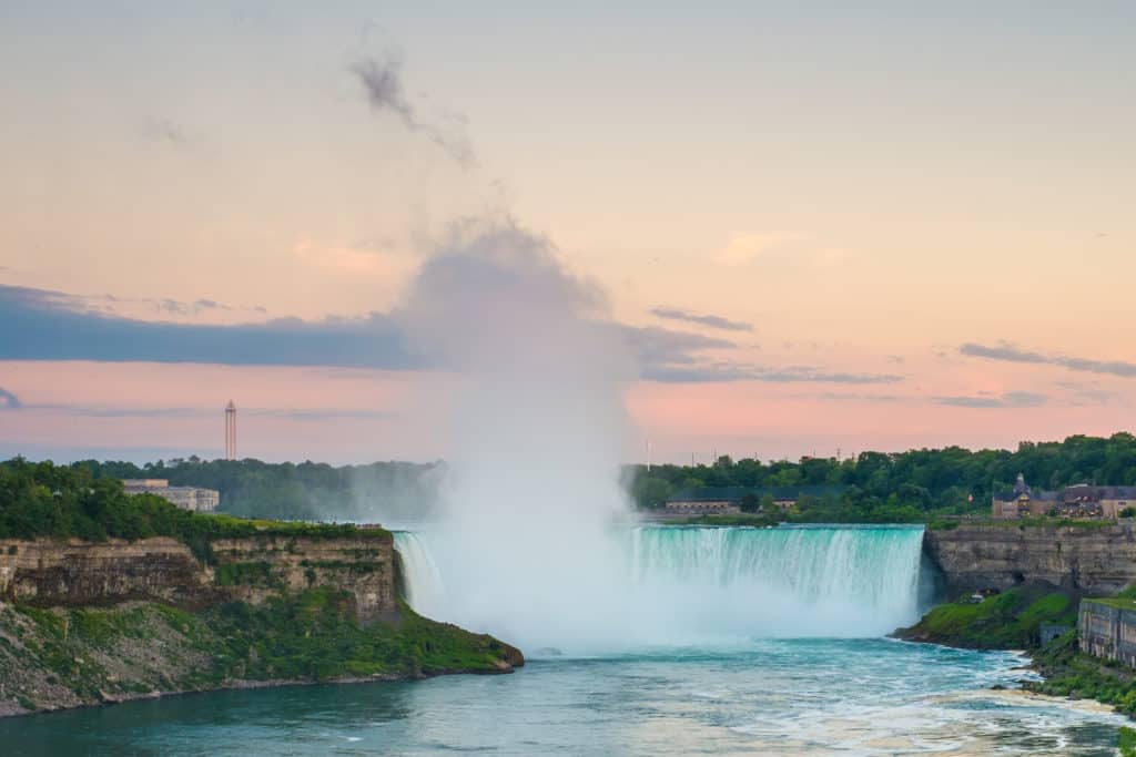 22489952 niagara falls evening Niagara Falls is the second-largest waterfall in the world. It is located on the North American continent, specifically on the common border between New York City in the United States of America and Toronto in Canada. 