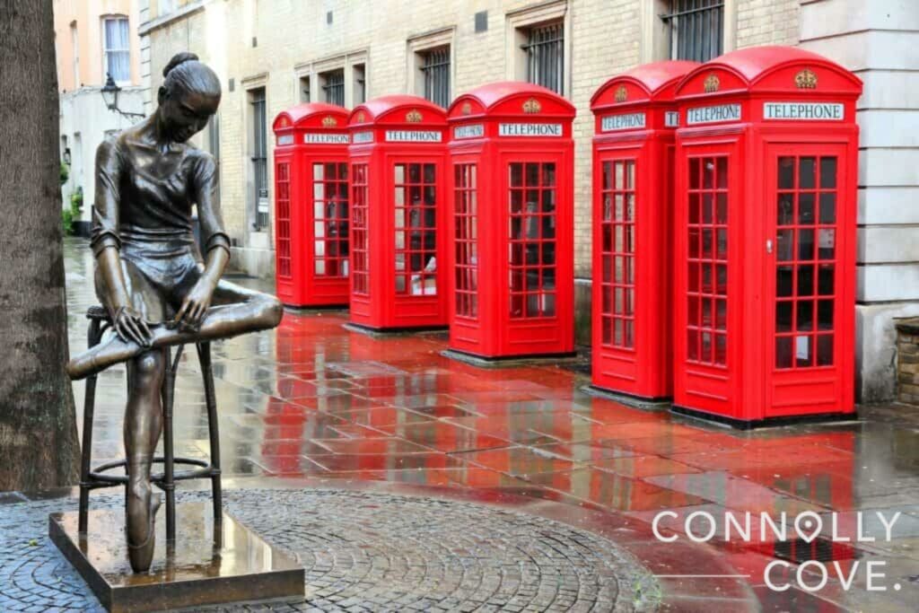 A row of phone booths in rainy London.
