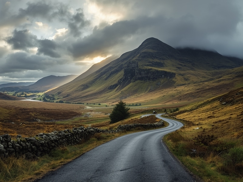 Dramatic Scottish Highlands landscape with mountains and winding road showcasing things to do in Scotland