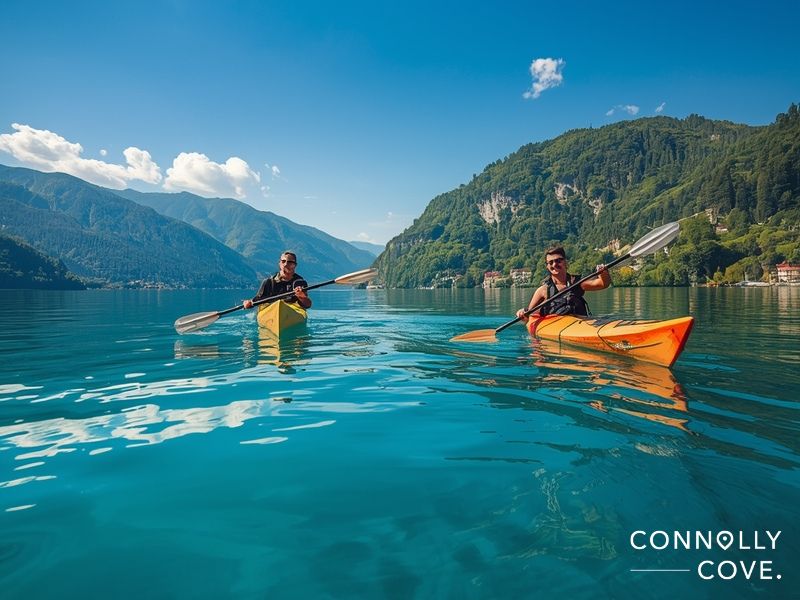 Kayaking on Lake Lugano's calm waters with Alpine mountain reflections and clear blue sky