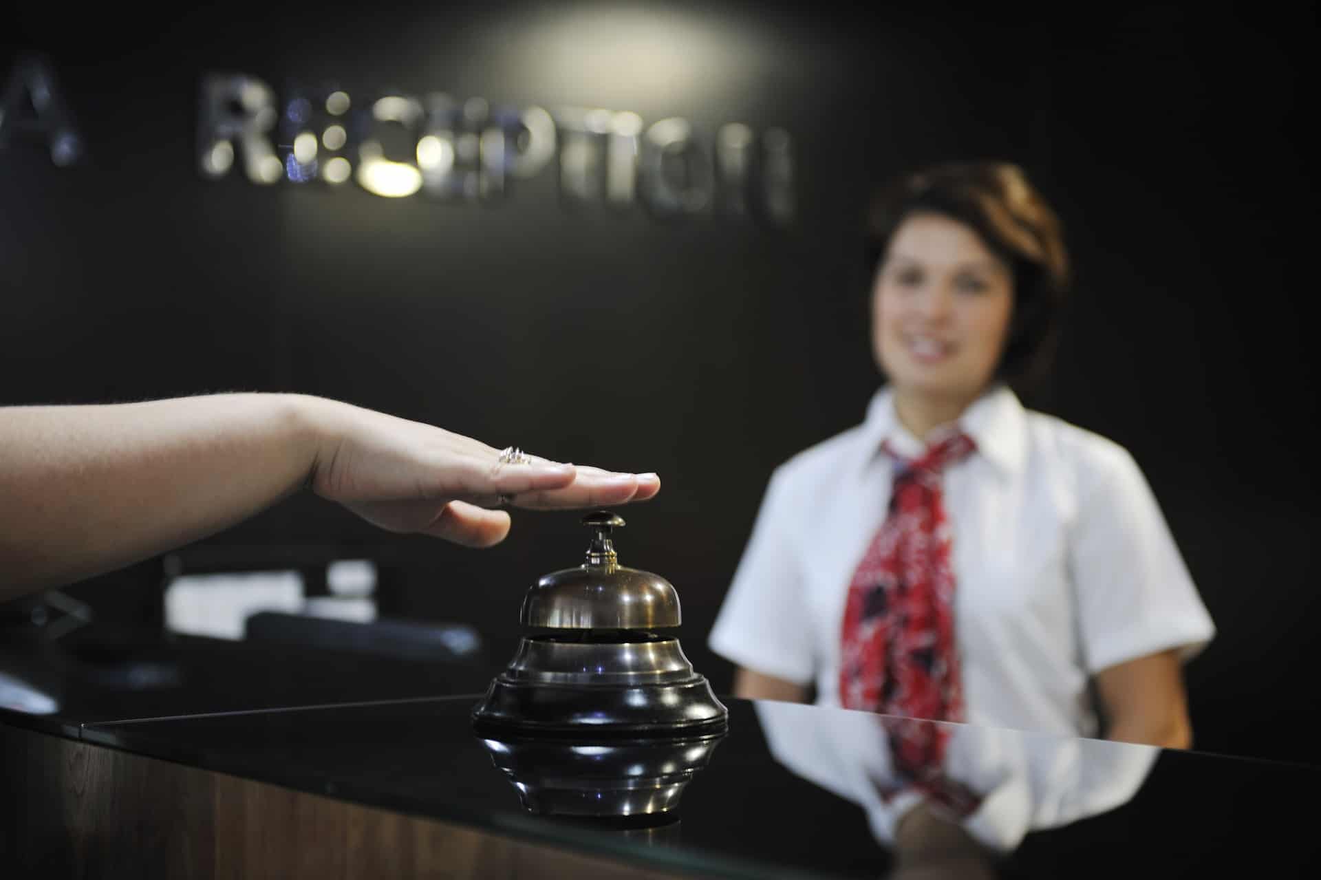A businesswoman smiling at the reception desk of the hotel