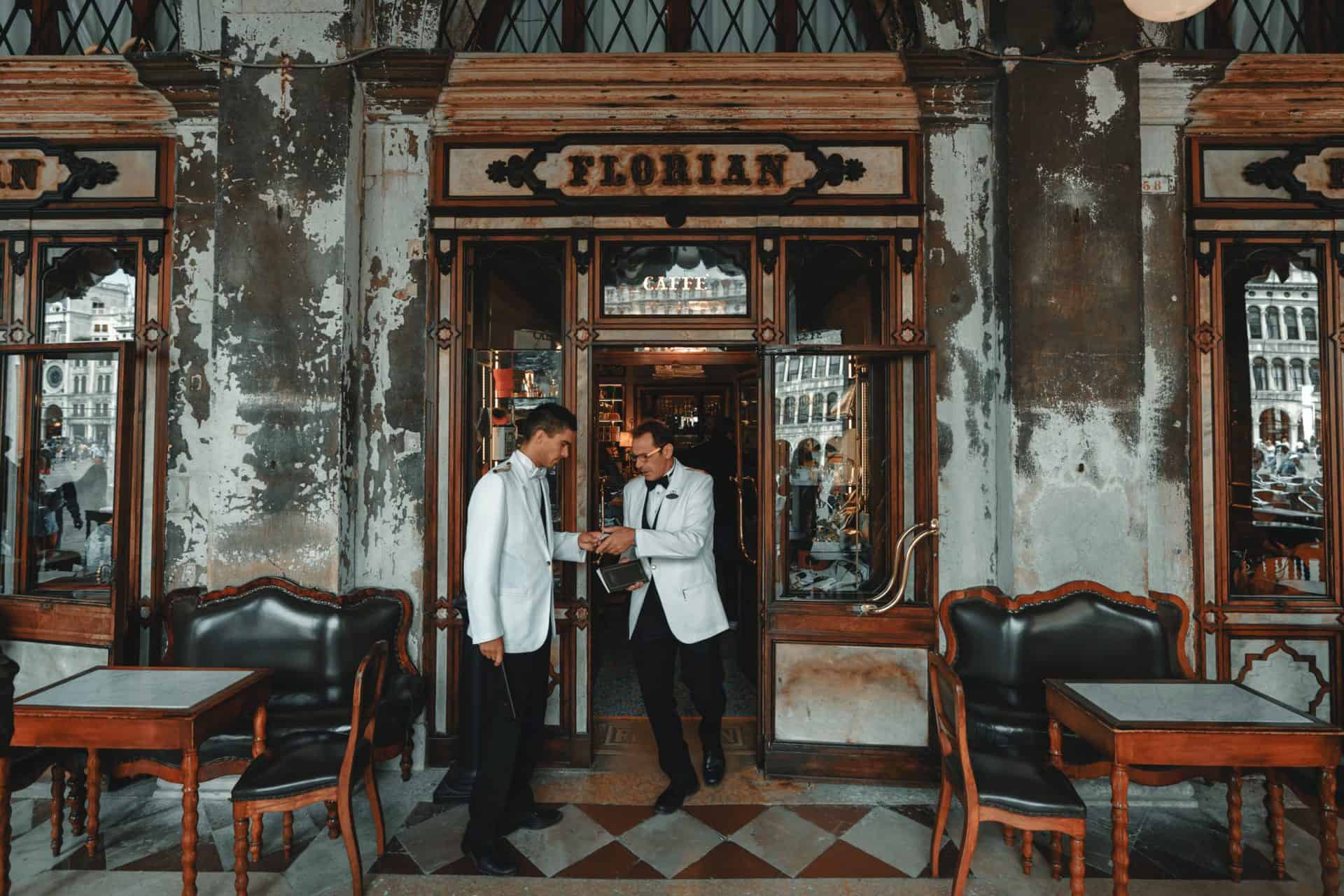 Two men discuss orders at Cafe Florian in Venice