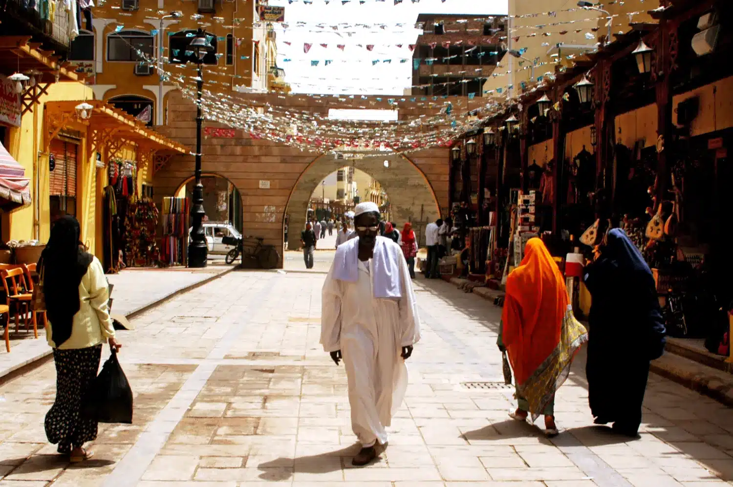 A lively scene in Nubian Villages, Aswan, as pedestrians leisurely walk down the street