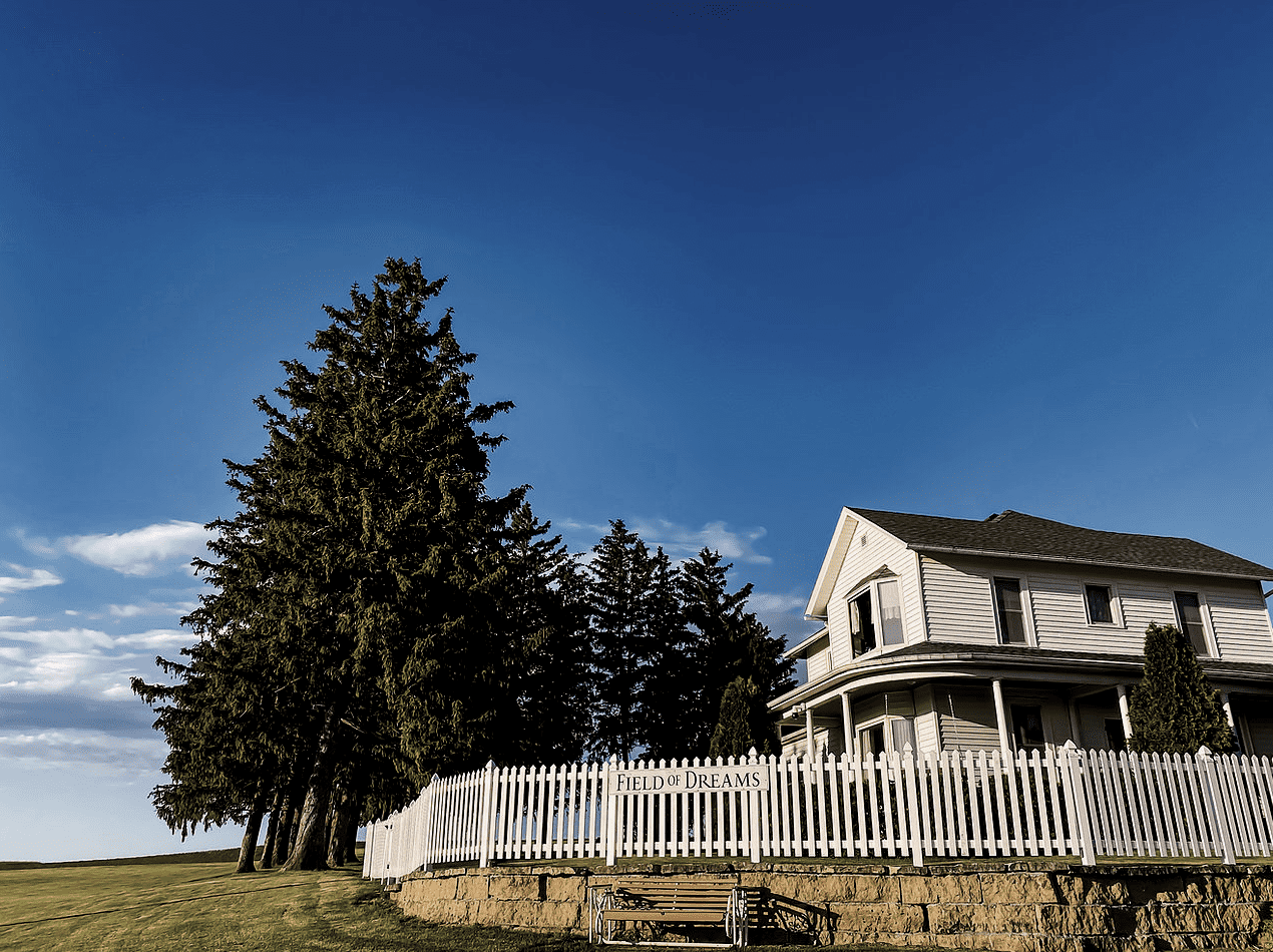 A colonial looking house with a white picket fence in America