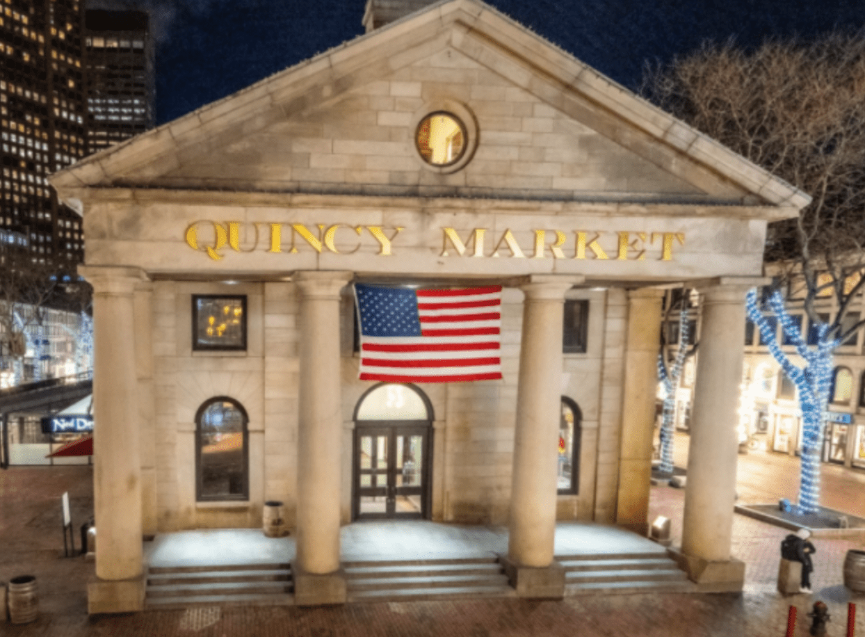 The front entrance of Quincy Market is lit at night in Boston