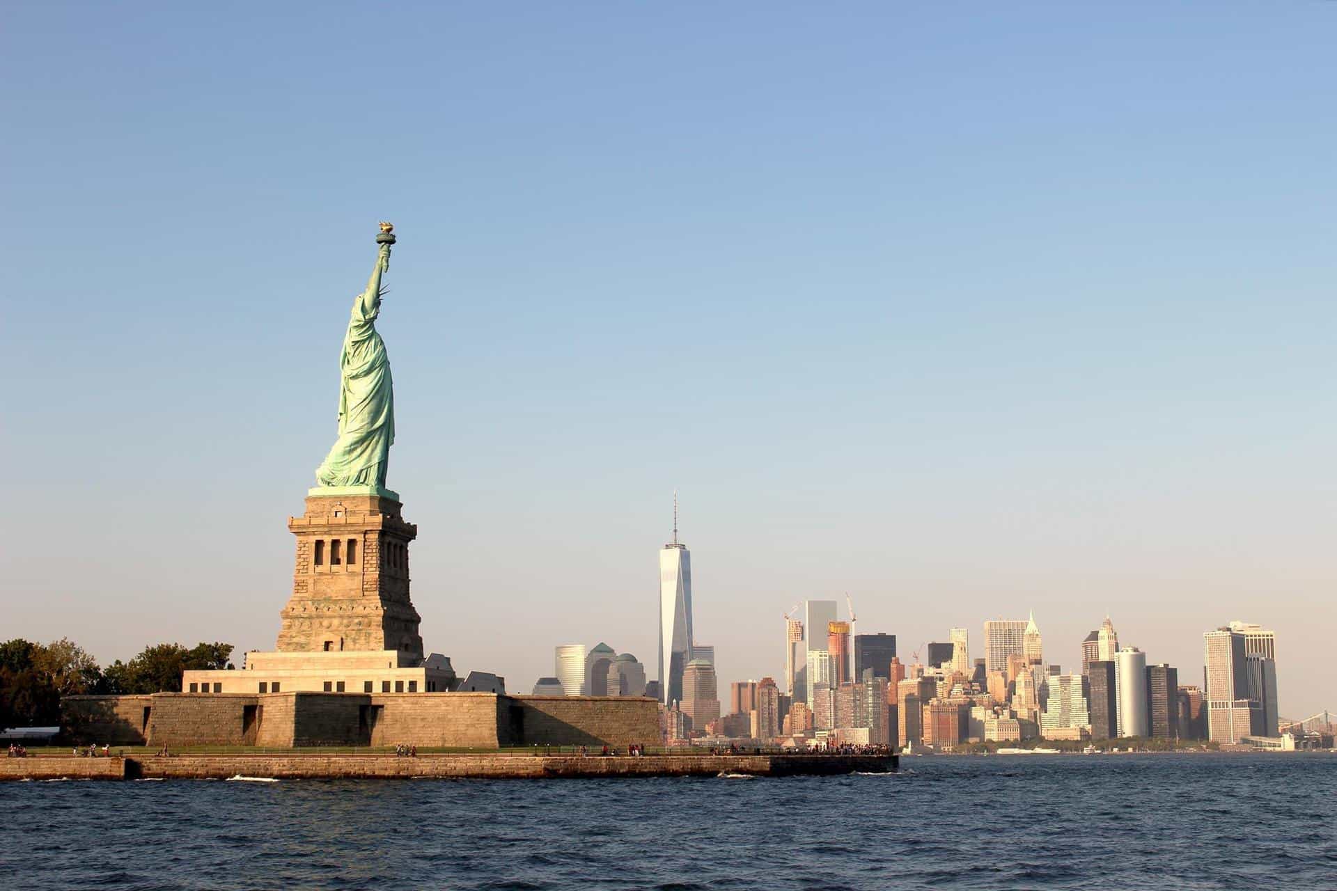 A wide shot of the back of the Statue of Liberty overlooking New York City