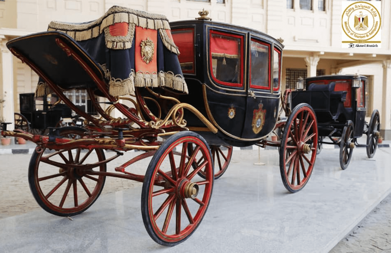 A black and red chariot on display at The Royal Chariots Museum in Egypt.