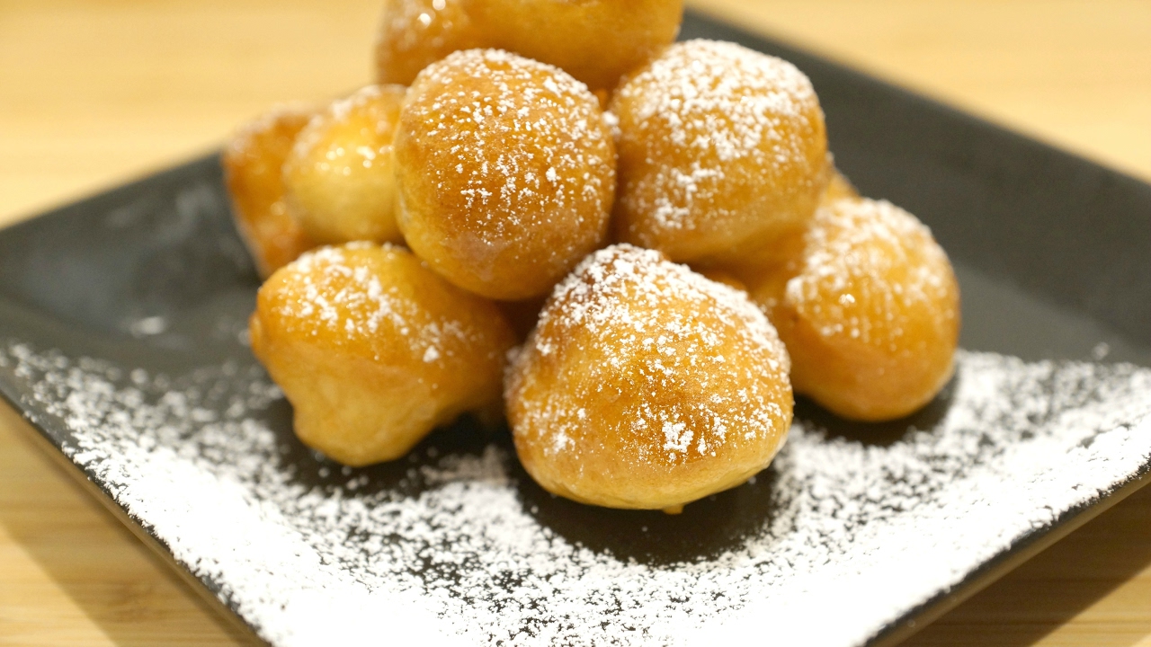 Zalabya Balls sprinkled with sugar on a plate.