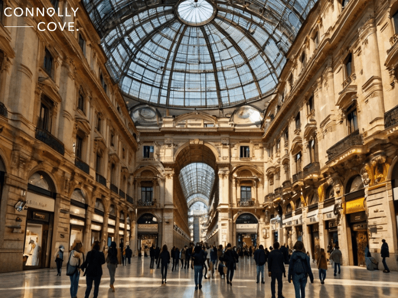 Galleria Vittorio Emanuele II

People walk inside Milan’s grand La Galleria Vittorio Emanuele II, an indoor shopping arcade with a glass-domed roof and ornate architecture. The well-lit scene has shops lining both sides of the elegant walkway.