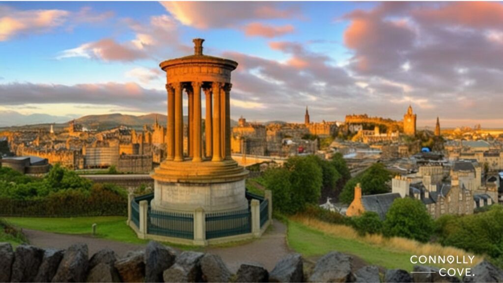 A sunset view of Edinburgh, Scotland, with the Dugald Stewart Monument in the foreground and iconic Scottish landmarks like Edinburgh Castle in the cityscape beneath a partly cloudy sky.