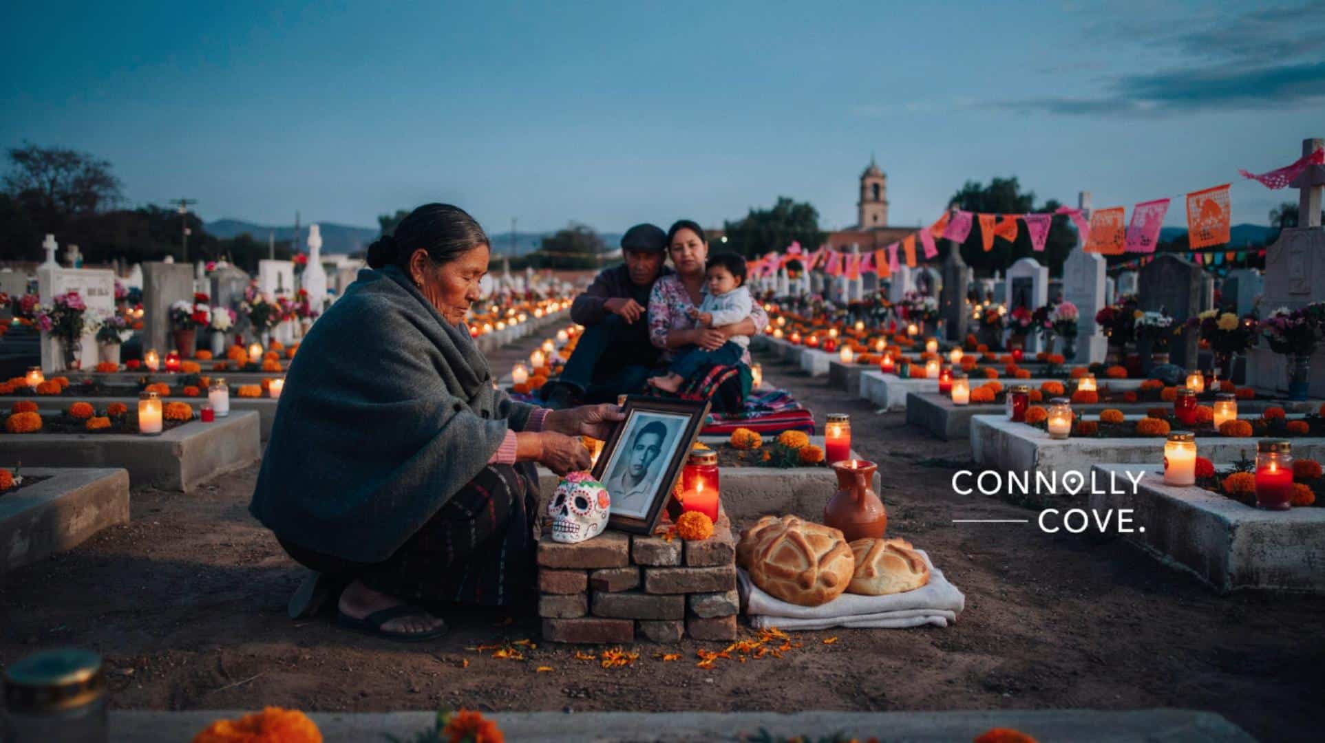 Family altar with marigolds, candles and pan de muerto in a village cemetery during Mexico's Day of the Dead