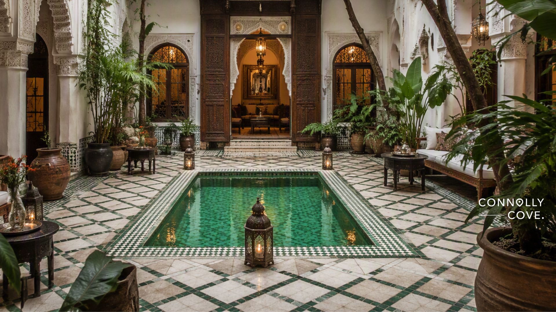 Elegant Moroccan courtyard with green-tiled pool, ornate arches, lush plants, lanterns, and wooden doors, creating a serene atmosphere reminiscent of traditional Moroccan Riads. Connolly Cove is written on the right side.